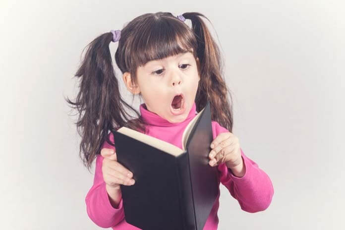 Petite fille réagit en lisant un livre